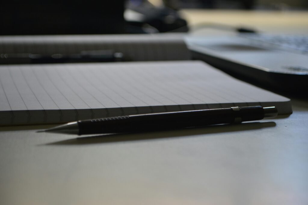 Detailed shot of a mechanical pencil placed on an open notebook, perfect for educational and office themes.